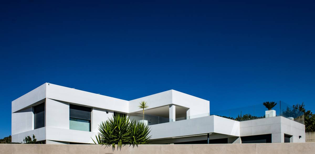 Smart outdoor wall outlet installed on stucco exterior with weatherproof cover and connected LED lighting